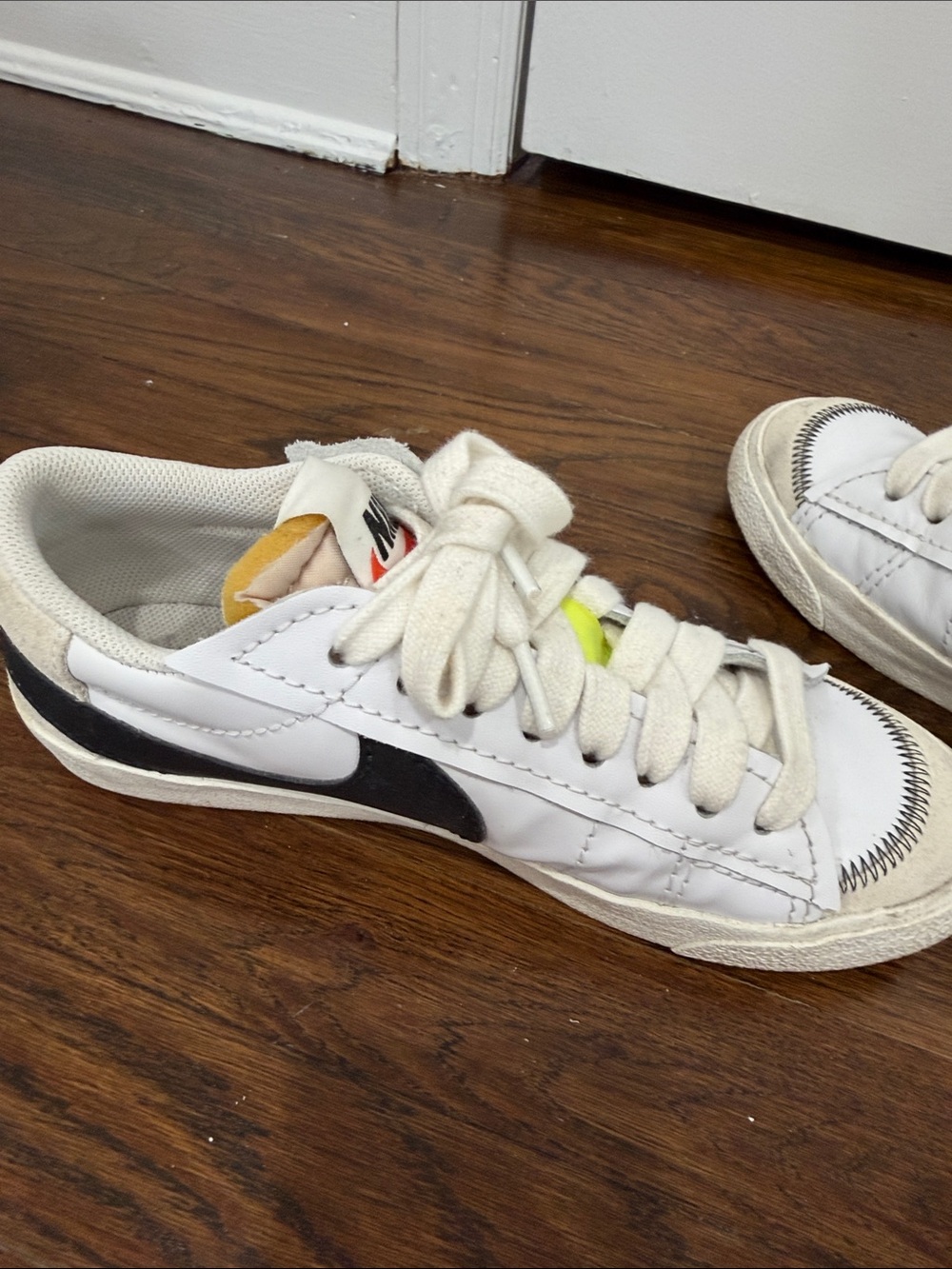 Nike Mens Blazer Low White Sneakers with Black Swoosh and Yellow Tongue Accent